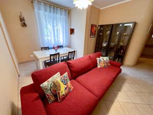 a red couch with pillows in a living room at A casa di Debby alloggio comodo e accogliente in Foligno