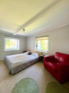a bedroom with a bed and a red couch at Corner House Plesna in Pleśna