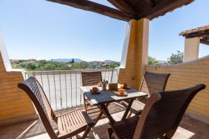 a wooden table and chairs on a deck with a view at Charming Room with two beds -2 minutes to the beach- in Olbia