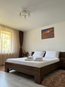 a bedroom with a large bed with white sheets at Ank's Apartment in Ocna-Mureşului