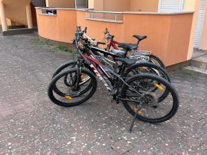 Duas bicicletas estão estacionadas ao lado de um edifício em Adriatic Oasis Apartments em Preko