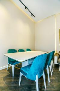 einen Konferenzraum mit einem weißen Tisch und blauen Stühlen in der Unterkunft Apartment VIP MARIOTT in Baku