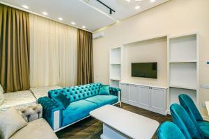een woonkamer met een blauwe bank en een tv bij Apartment VIP MARIOTT in Baku