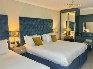 um quarto de hotel com duas camas e um espelho em Hotel Collingwood BW Signature Collection em Bournemouth