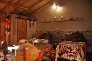 Valle Dorado Lodge في كوسكو: غرفة معيشة مع طاولة وأريكة