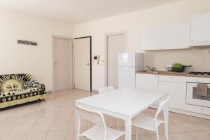 una cucina bianca con tavolo e divano di Cornigliano Apartment 3 a Genova