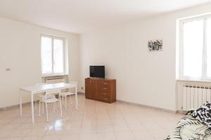 un soggiorno bianco con tavolo e TV di Cornigliano Apartment 3 a Genova