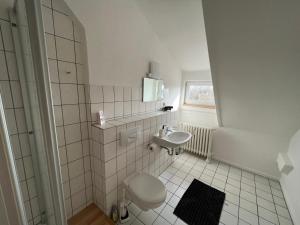 a white bathroom with a sink and a toilet at MWMGästehaus Doppelzimmer 17 in Meine
