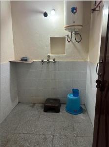 a bathroom with a urinal with a blue stool at Rukmani Home Stay in Mathura