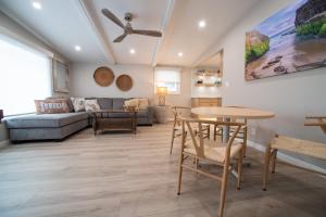 a living room with a table and chairs and a couch at La Jolla Windansea Luxury Apt in San Diego +21 photos