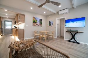 a living room with a table and a tv at La Jolla Windansea Luxury Apt in San Diego