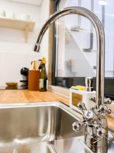 a kitchen sink with a faucet in a kitchen at Casa Melro in Faro +10 photos