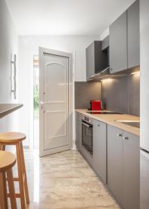 een keuken met witte kasten en een witte deur bij Minimalist apartment near the airport and the city center in Kanálion