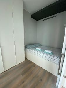 a small bedroom with a bed and a wooden floor at Victory House in Milan