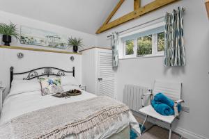 a bedroom with a bed and a chair at The Boathouse - Panoramic Sea View Retreat, near Town, Marina & Beach, with Parking in Torquay