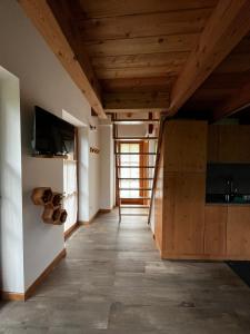 Camera con soffitto in legno e cucina. di Il nido al Maso Maoro a Sant’Orsola