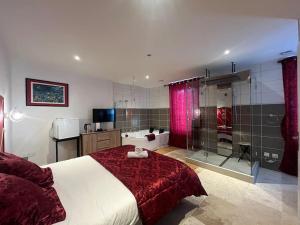 a bedroom with a large bed and a bathroom at La Suite Love de l Écu in Villeneuve-sur-Yonne