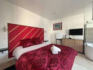 a bedroom with a large bed with a red headboard at La Suite Love de l Écu in Villeneuve-sur-Yonne