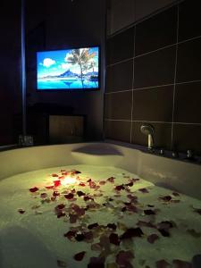 a bathroom with a bath tub with flowers on the floor at La Suite Love de l Écu in Villeneuve-sur-Yonne