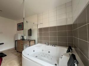 a large white bath tub in a bathroom at La Suite Love de l Écu in Villeneuve-sur-Yonne +7 photos