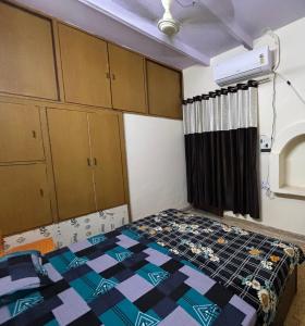a small room with a bed and some cabinets at Rukmani Home Stay in Mathura