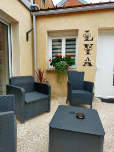 eine Terrasse mit Stühlen, einem Tisch und einem Fenster in der Unterkunft La maison de LYA (lyaroom) 