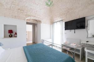 sypialnia z łóżkiem, stołem i telewizorem w obiekcie B&B Villa Vittoria Ostuni w mieście Ostuni