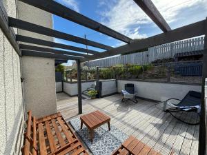 a patio with a wooden bench and a table at Craster Crew Quarters in Craster