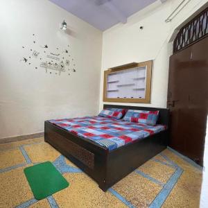a small bedroom with a bed in a room at Rukmani Home Stay in Mathura