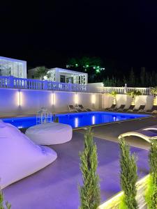 a swimming pool at night with chairs and lights at Hotel Sirena - Servizio spiaggia inclusive in Peschici