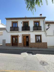 a white house with windows and balconies on a street at Casa Flamenco - Casco Antiguo in Antequera