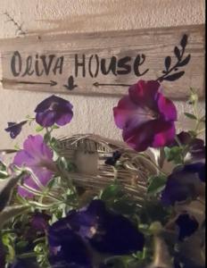 uma placa que diz casa olva com flores roxas em Quinta da Maínha - Charming Houses em Braga