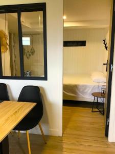una camera con tavolo, letto e specchio di VUE LAC LODGES a Sevrier