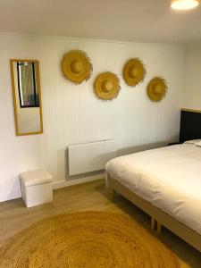 una camera da letto con un letto e quattro cappelli di paglia sul muro di VUE LAC LODGES a Sevrier