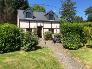 a white house with a pathway leading to it at Rose Cottage with seasonal Swimming Pool in Le Mesnil-Gilbert