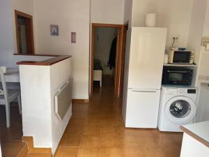 a kitchen with a refrigerator and a washing machine at Villa Los Silos in Costa Calma
