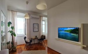 a living room with a flat screen tv on a wall at Vlatkovićeva Apartments in Senj