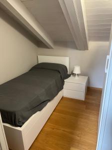 a bedroom with a bed and a night stand with a lamp at Appartamento Scoggione in Colico