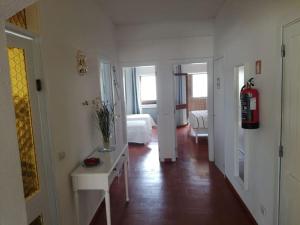Un pasillo blanco con una habitación con una cama y una boca de incendios. en Four Seasons House, en Monte Gordo 18 fotos más