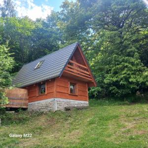 una piccola cabina in legno su una collina con alberi di Domek Bacówka Pod Lipą a Lipowa