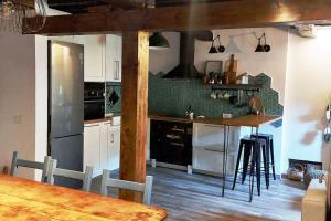 a kitchen with white cabinets and a table with chairs at El Cuadro de Llanes in Vibaño