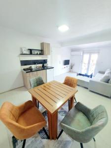 un soggiorno con tavolo in legno e 2 sedie di Eftimija Apartments a Gevgelija