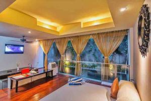 a living room with a large window at Venus- 1br pvt pool villa in kuta By iLys Collection in Kuta