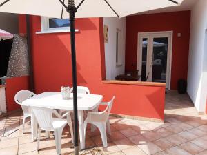 a white table with white chairs and an umbrella at La Casa dei Pescatori in Caorle