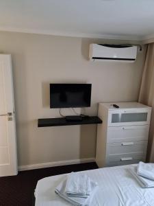 Un dormitorio con una cama y un televisor en la pared. en Atlas Unirii, en Buzau