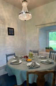 une table à manger avec un chiffon bleu et un lustre dans l'établissement Türisalu puhkemaja, à Türisalu