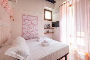 a bedroom with a white bed with two towels on it at maison Trevi in Rome