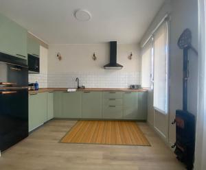 an empty kitchen with green cabinets and a window at Los tucanes in Haro