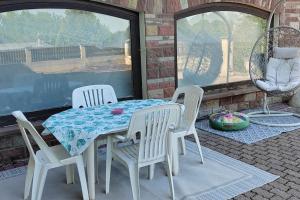 a table and four chairs on a patio at Appartement spacieux 75m2 in LʼHôpital