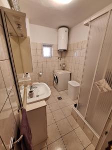 a bathroom with a sink and a toilet at Apartmani Eškinja in Biograd na Moru